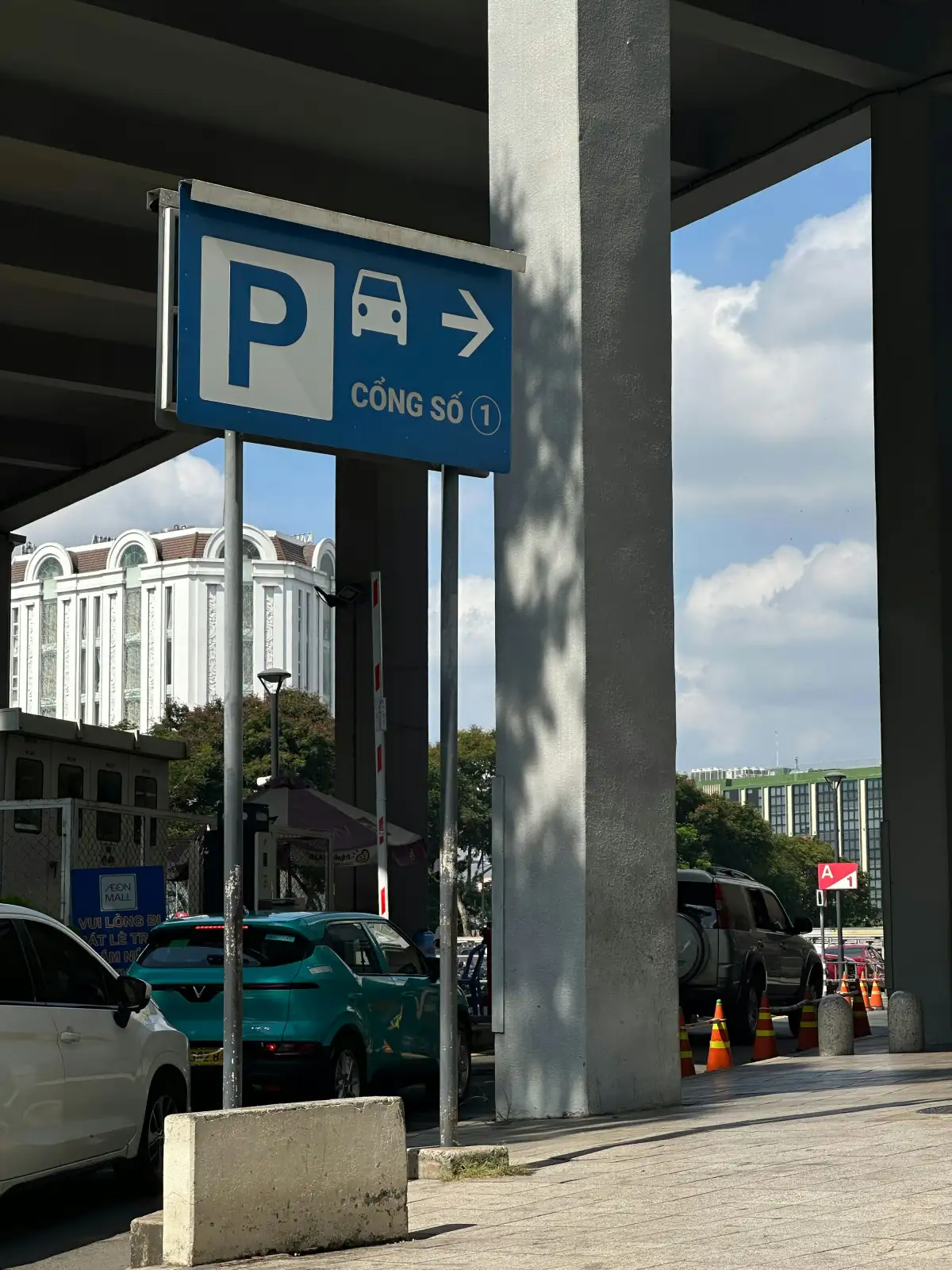 a blue and white street sign next to a parking lot